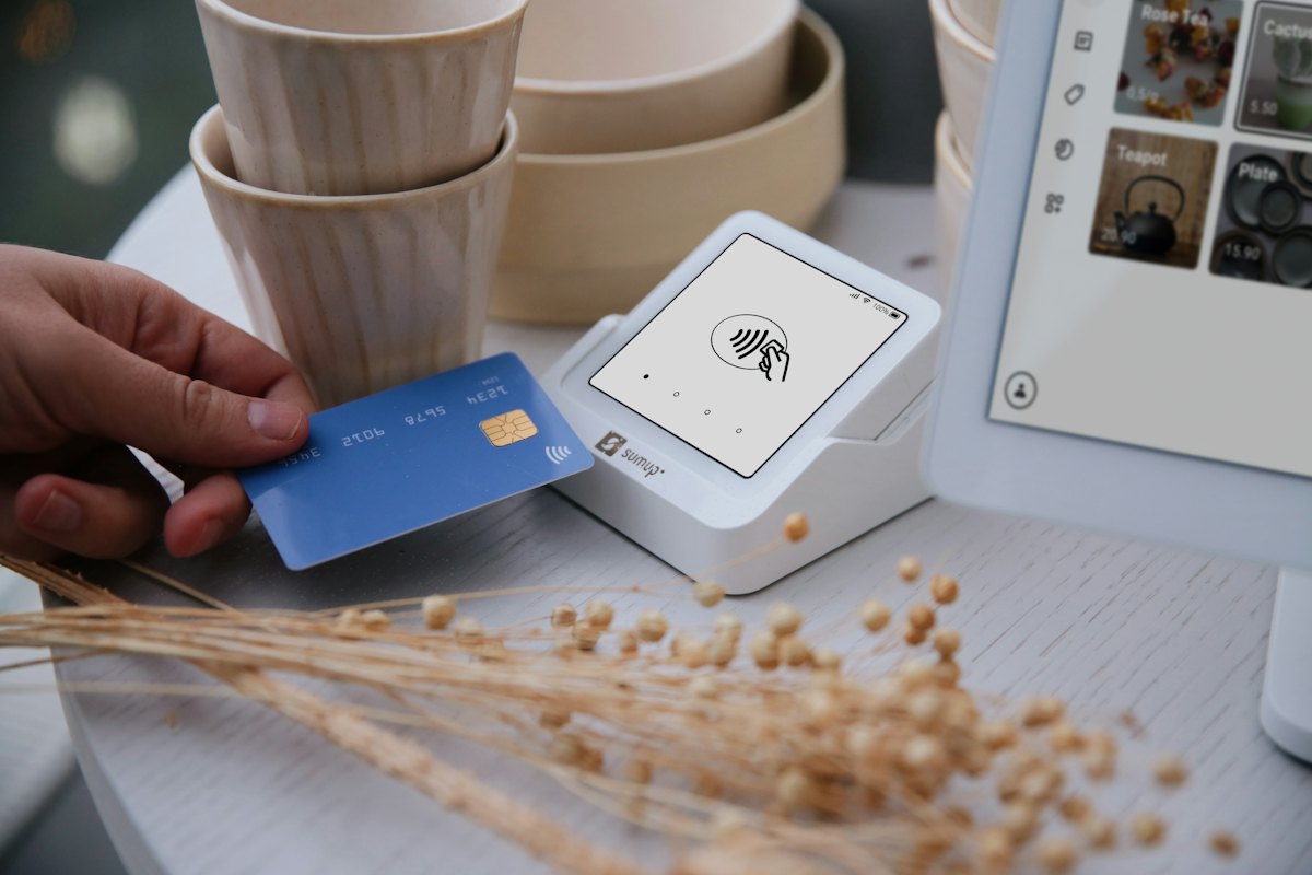 A customer tapping a card on a point-of-sale terminal